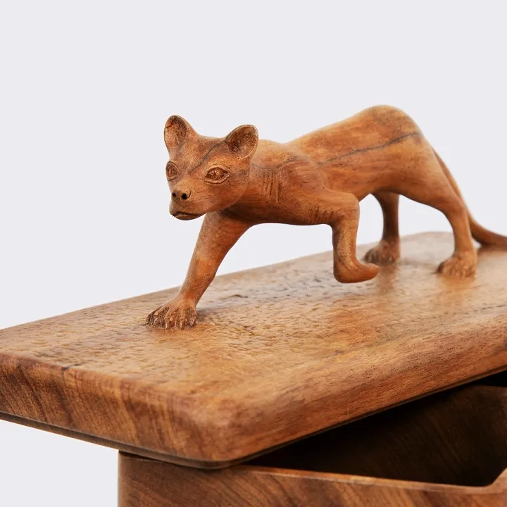 Handcrafted wooden jewelry box with carved animal sculpture on lid, artisanal home decor in natural wood.