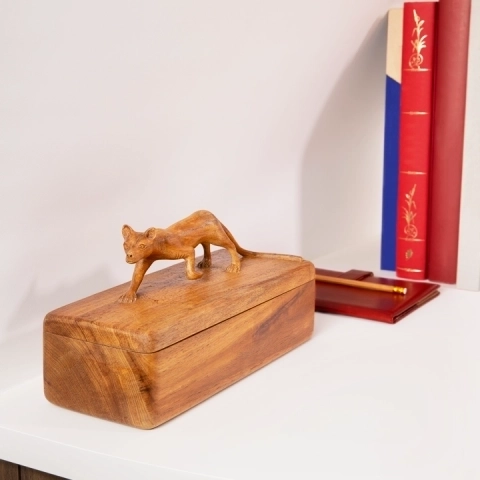 Handcrafted wooden jewelry box with carved animal sculpture on lid, artisanal home decor in natural wood.